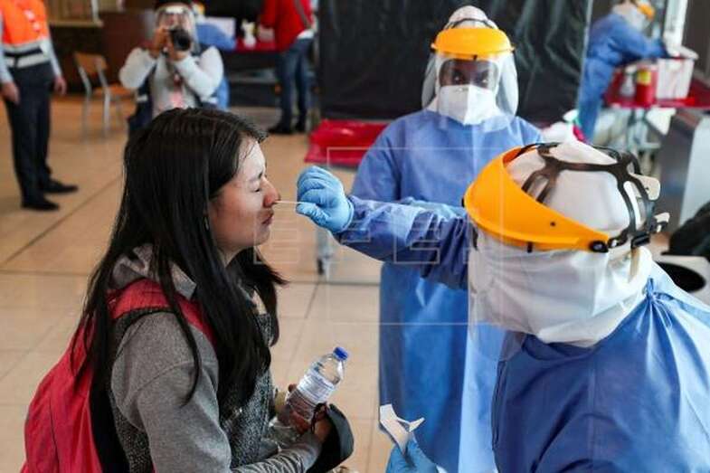 Personal médico realiza pruebas PCR en un aeropuerto (Foto EFE / José Jácome)